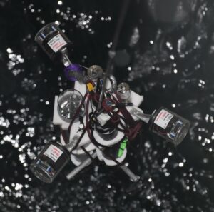 Measuring equipment on metal frame seen from above, being lowered down into water